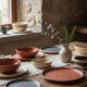 Vaixella rústica de ceràmica artesanal en tons naturals.